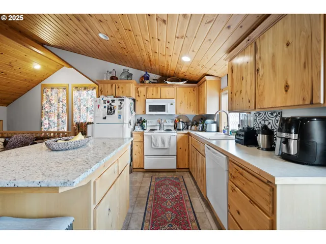 a kitchen with stainless steel appliances granite countertop a sink a stove and cabinets