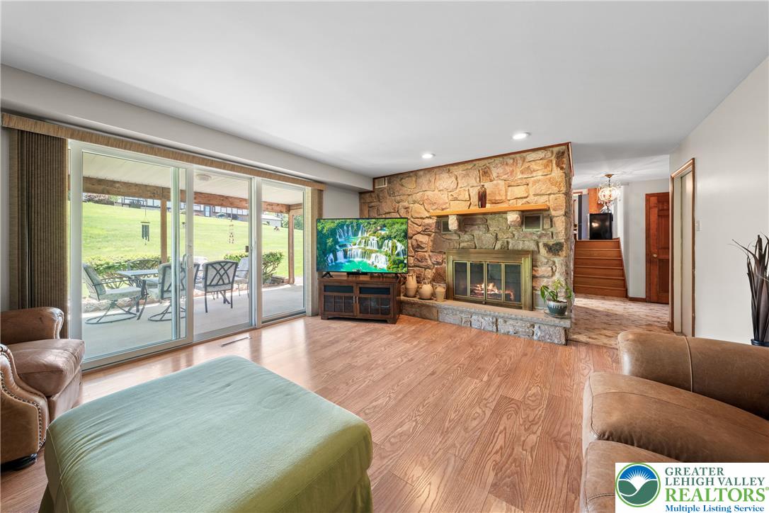 947 Tamenend Road Bath, PA 18014 - Photo 5 of 61 A spacious great room featuring a natural stone fireplace and direct outdoor access through sliding glass doors.