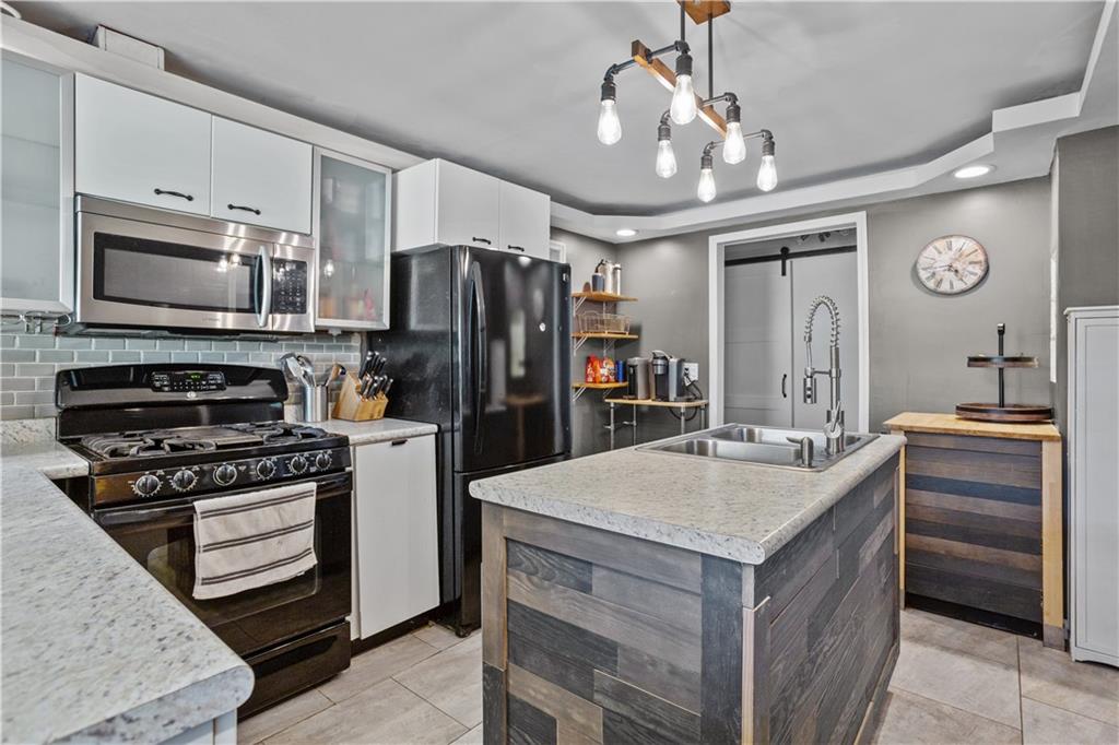 1129 Edith Avenue Pittsburgh, PA 15236 - Photo 11 of 25 a kitchen with a center island and stainless steel appliances
