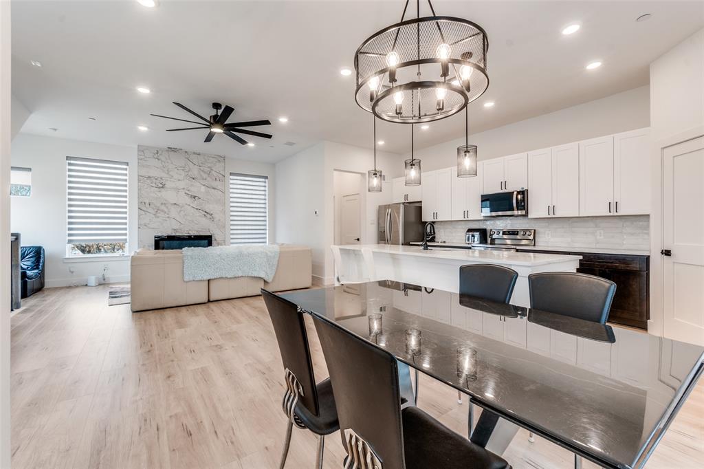 2134 Shea Road, Unit 1001 Dallas, TX 75235 - Photo 3 of 12 a kitchen with stainless steel appliances a stove a refrigerator a microwave a stove and white cabinets with wooden floor