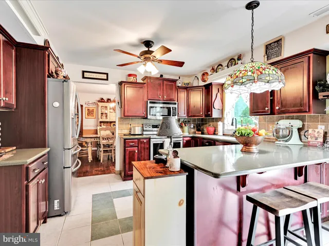 a kitchen with kitchen island granite countertop a center island a stove and a chandelier