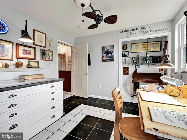 a living room with furniture and paintings on the wall