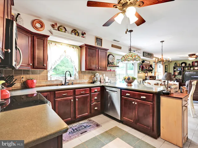a kitchen with stainless steel appliances granite countertop a sink a stove and a wooden cabinets