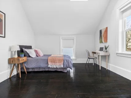 a bedroom with a bed and wooden floor