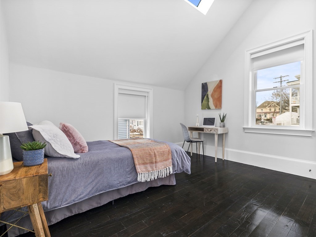 131 Centre Street Boston, MA 02124 - Photo 17 of 26 a bedroom with a bed and wooden floor