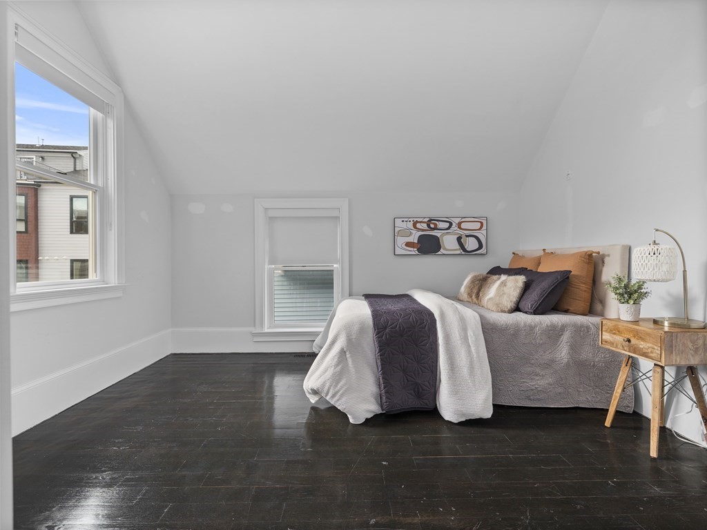 131 Centre Street Boston, MA 02124 - Photo 20 of 26 a spacious bedroom with a bed and wooden floor