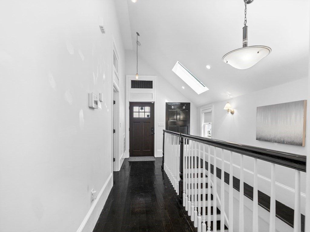 131 Centre Street Boston, MA 02124 - Photo 5 of 26 a view of a hallway with wooden floor and staircase