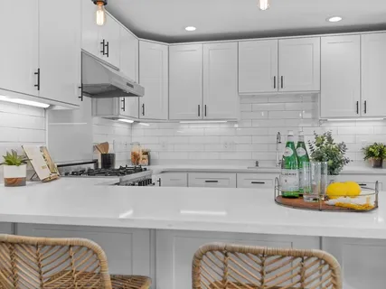 a kitchen with a sink a white cabinets and appliances