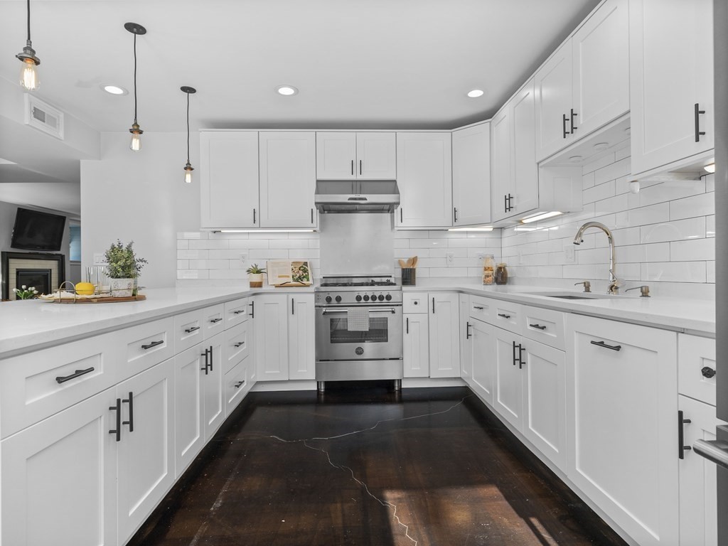 131 Centre Street Boston, MA 02124 - Photo 8 of 26 a kitchen with granite countertop white cabinets and white appliances