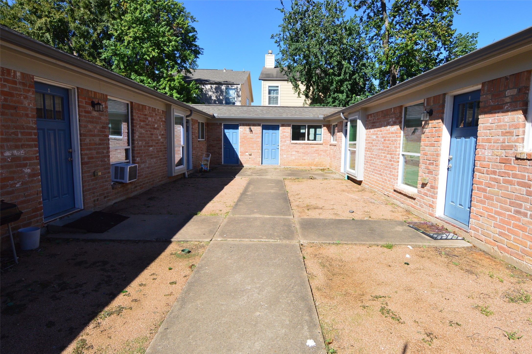 10002 Neuens Road, Unit 2 Houston, TX 77080 - Photo 13 of 15 a view of backyard with large trees and wooden fence