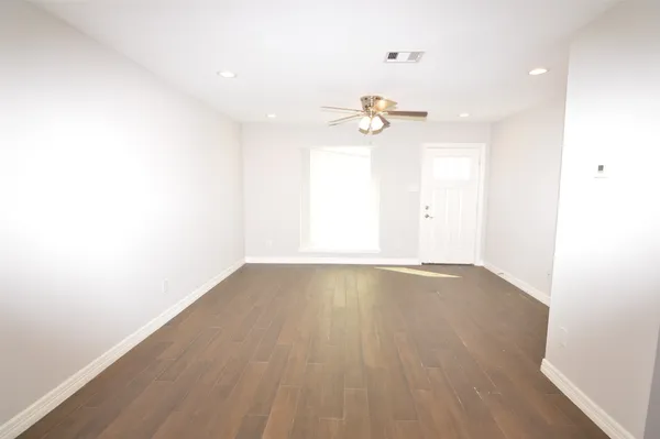 an empty room with a window and a ceiling fan