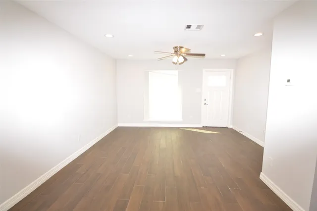 an empty room with a window and a ceiling fan