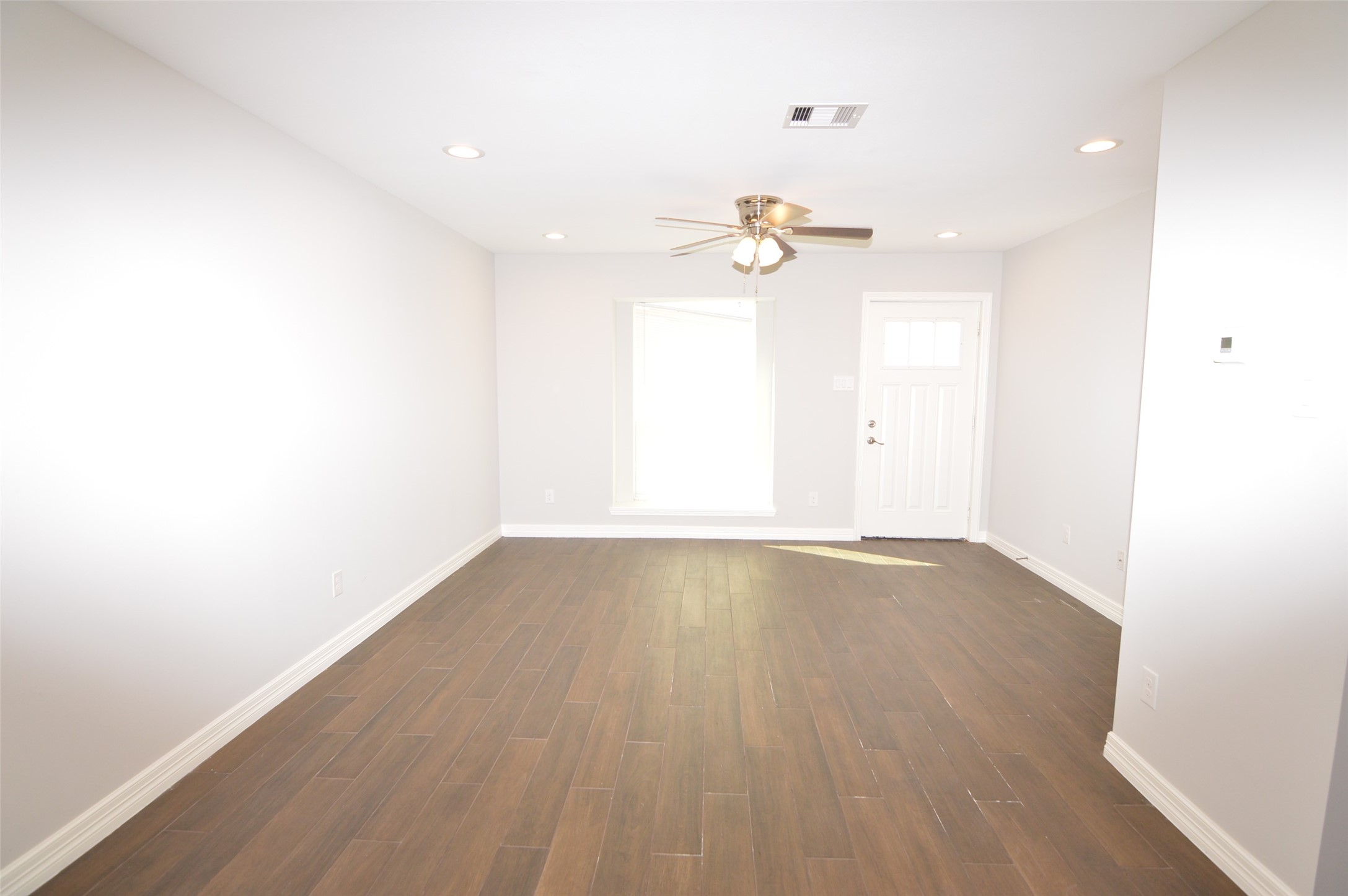 10002 Neuens Road, Unit 2 Houston, TX 77080 - Photo 2 of 15 an empty room with a window and a ceiling fan