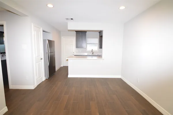 a view of a kitchen with wooden floor and a sink
