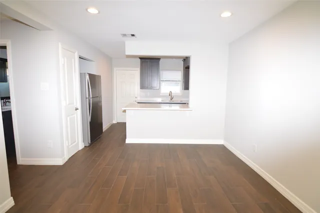 a view of a kitchen with wooden floor and a sink