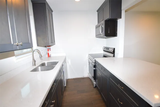 a kitchen with a sink stove and microwave