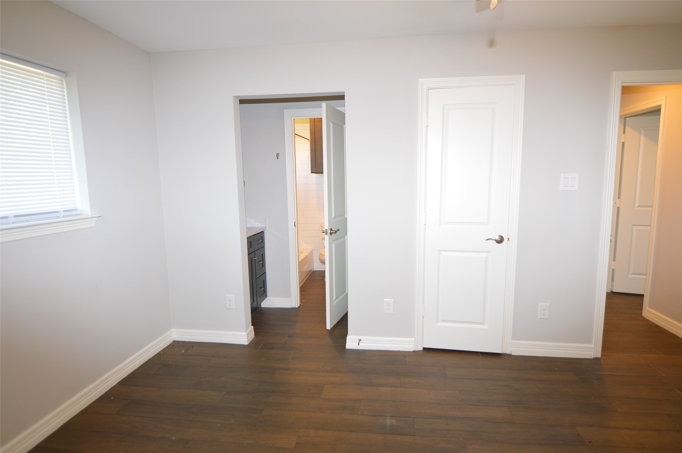 10002 Neuens Road, Unit 2 Houston, TX 77080 - Photo 8 of 15 an empty room with wooden floor and a window
