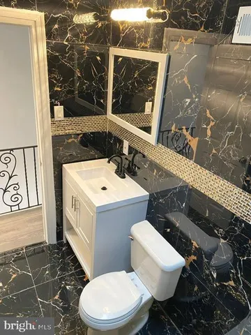 a white toilet sitting next to a bathroom sink