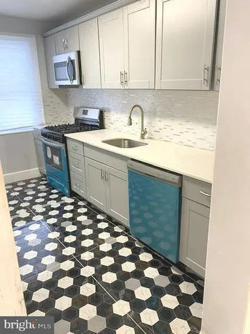 a kitchen with a sink a stove and cabinets