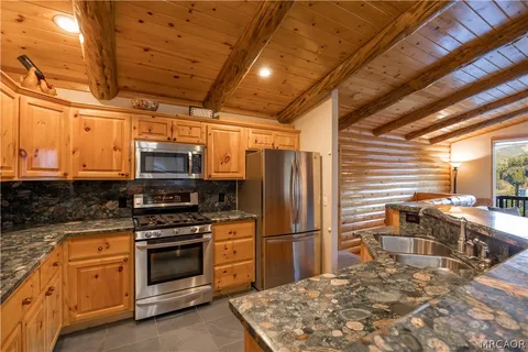 a kitchen with stainless steel appliances granite countertop a stove a sink and a refrigerator