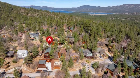 an aerial view of residential houses with outdoor space and trees