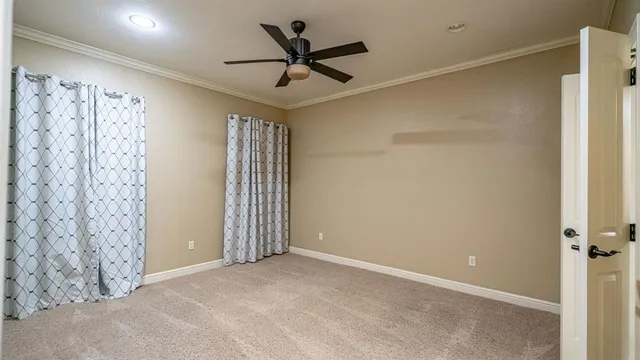an empty room with a chandelier fan
