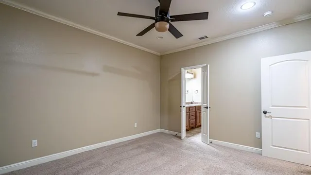 an empty room with closet and a chandelier fan