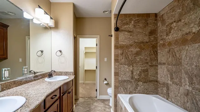 a bathroom with a granite countertop sink a mirror and a shower