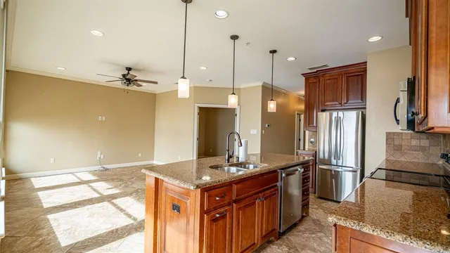 a kitchen with stainless steel appliances granite countertop a refrigerator a sink and a stove