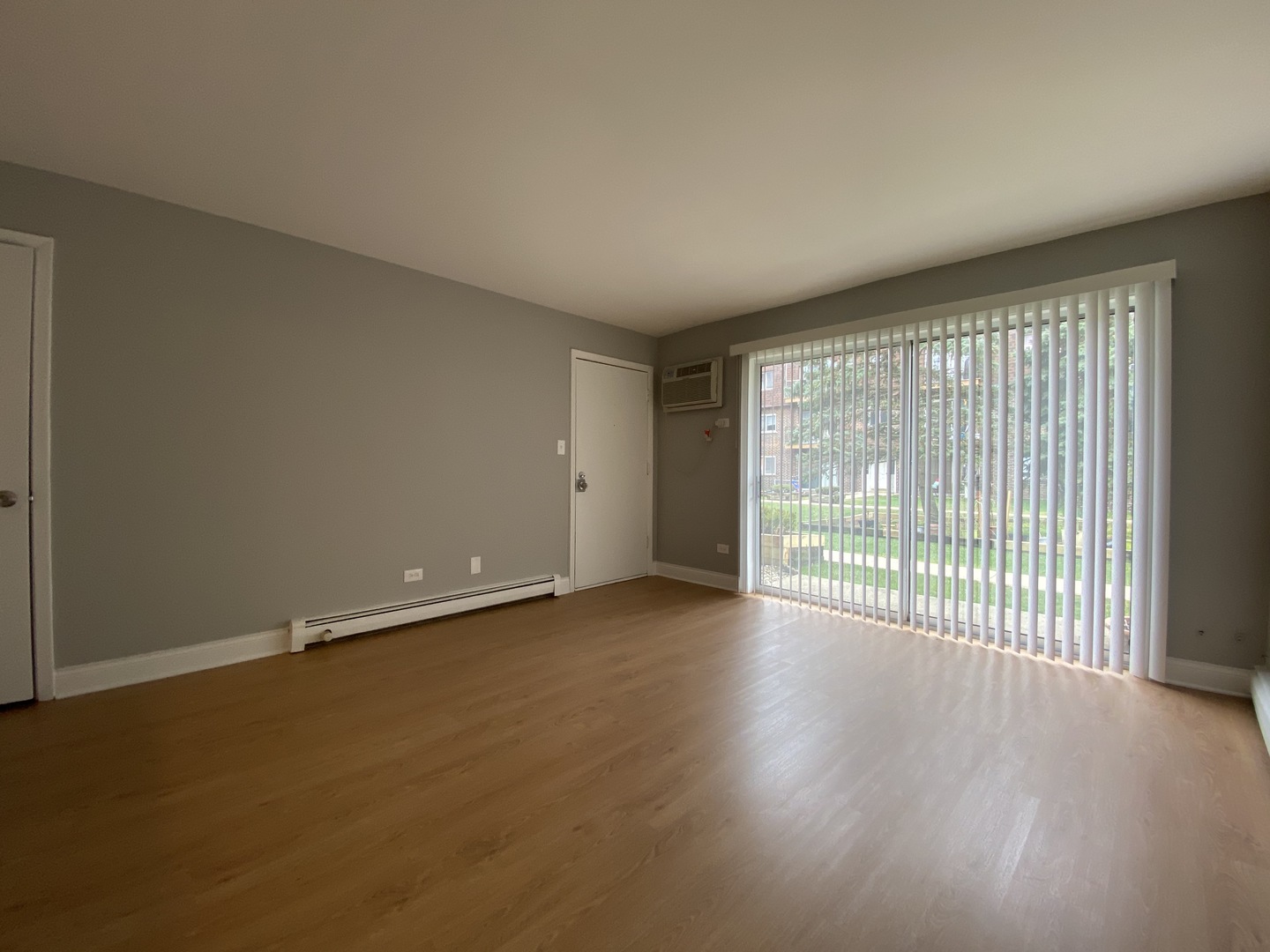 9368 Golf Road, Unit 1A Des Plaines, IL 60016 - Photo 2 of 21 a view of an empty room with wooden floor and a window