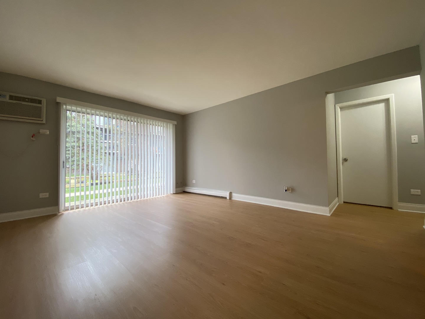 9368 Golf Road, Unit 1A Des Plaines, IL 60016 - Photo 3 of 21 an empty room with wooden floor and windows