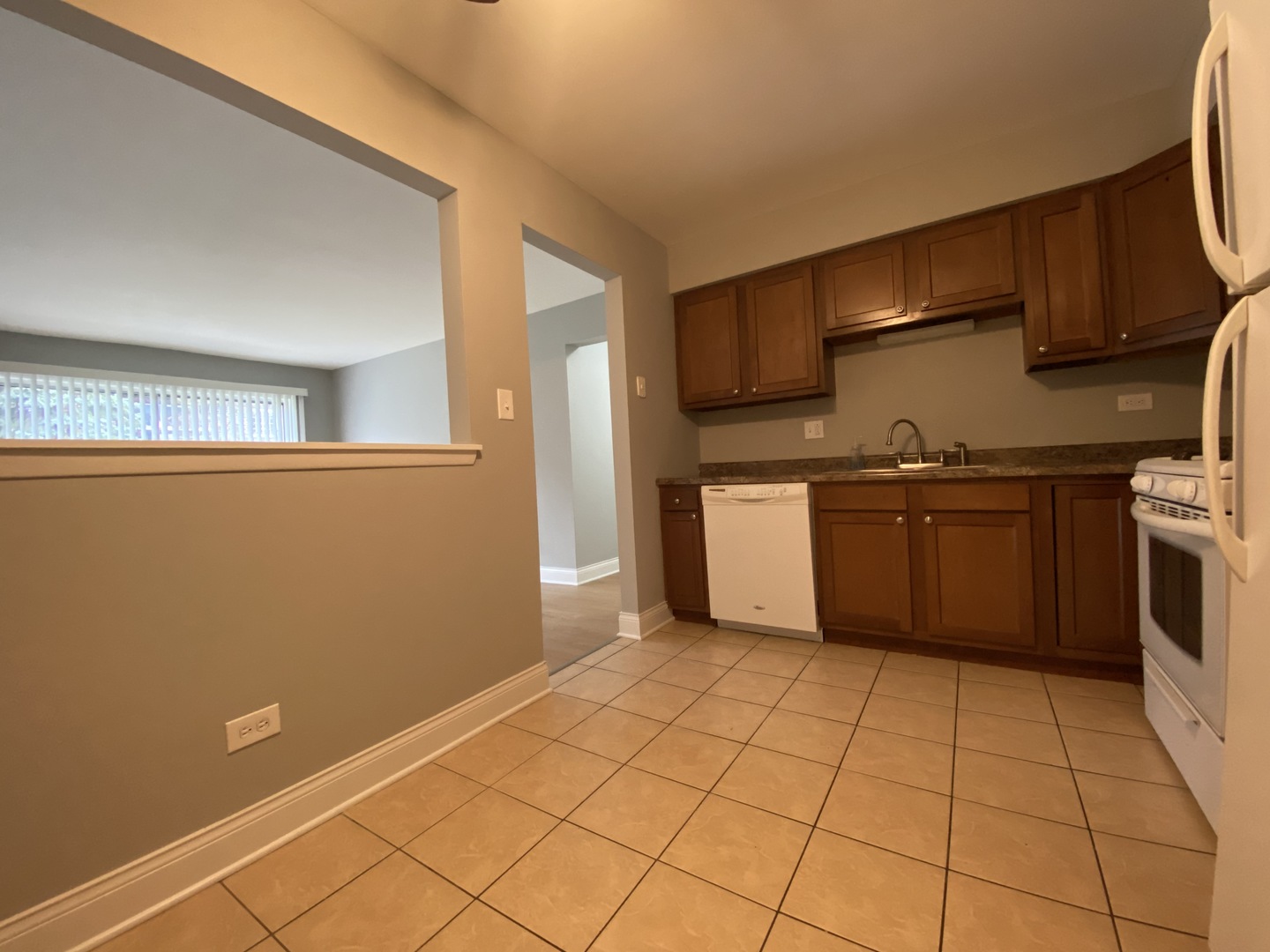 9368 Golf Road, Unit 1A Des Plaines, IL 60016 - Photo 8 of 21 a kitchen with stainless steel appliances granite countertop a sink stove and refrigerator