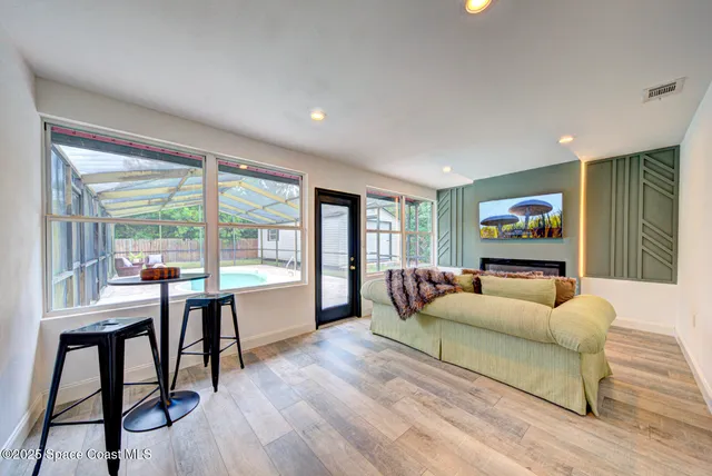 a living room with furniture and a flat screen tv with wooden floor