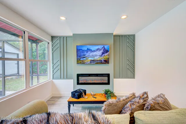 a living room with furniture kitchen view and a large window
