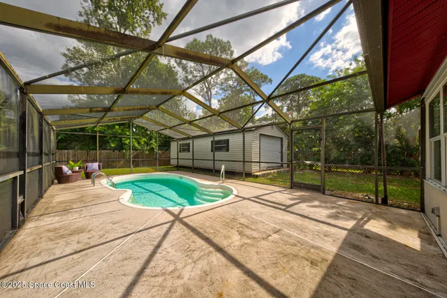 a view of a backyard with table and chairs under an umbrella