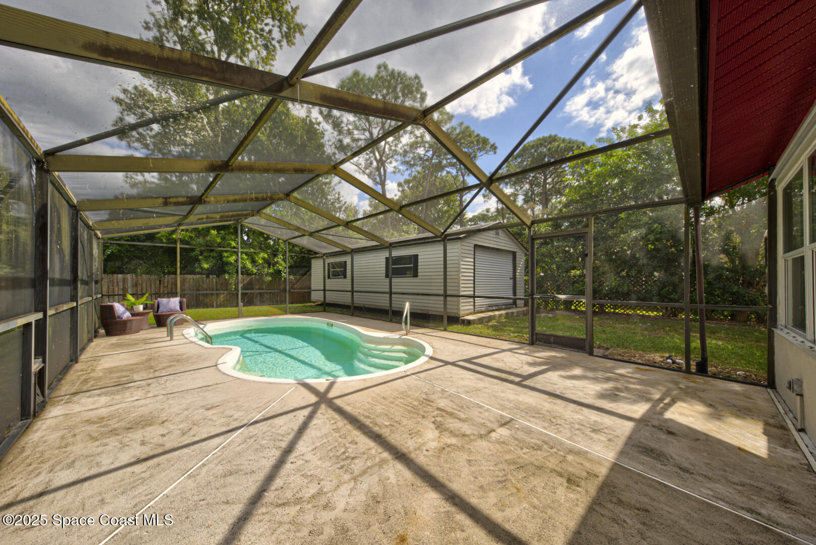 5049 Jamaica Road Cocoa, FL 32927 - Photo 19 of 24 a view of a backyard with table and chairs under an umbrella