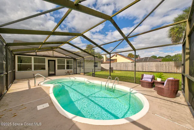 a view of a swimming pool with a couches chairs and a table