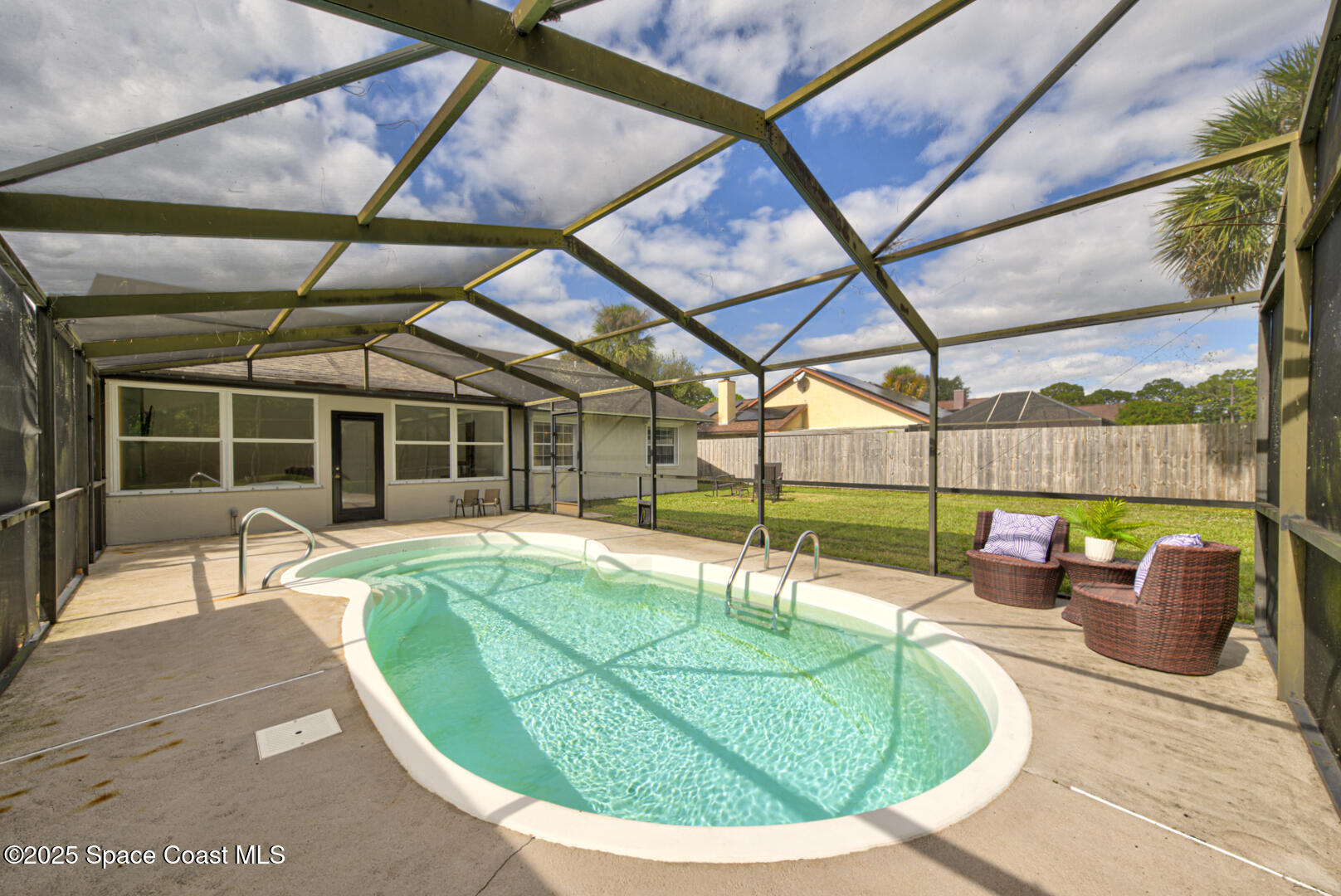 5049 Jamaica Road Cocoa, FL 32927 - Photo 21 of 24 a view of a swimming pool with a couches chairs and a table