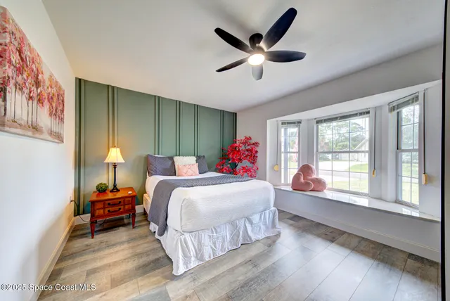 a living room with a bed furniture and a large window