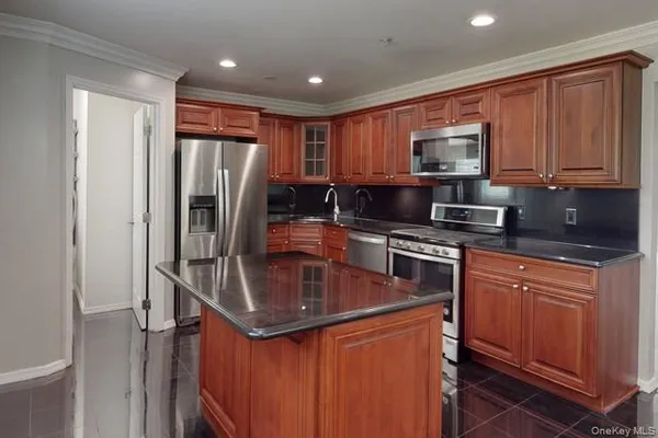 a kitchen with stainless steel appliances granite countertop a refrigerator stove and sink