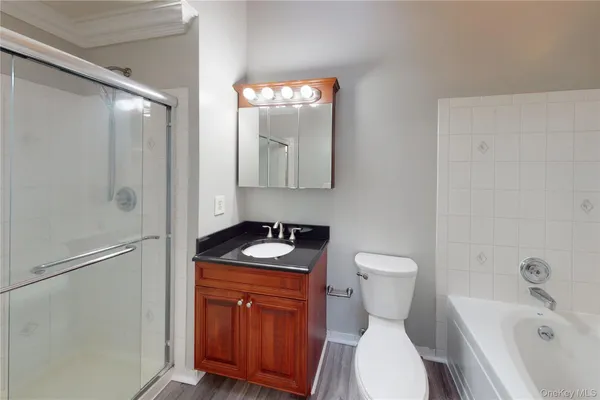 a bathroom with a granite countertop toilet sink and mirror