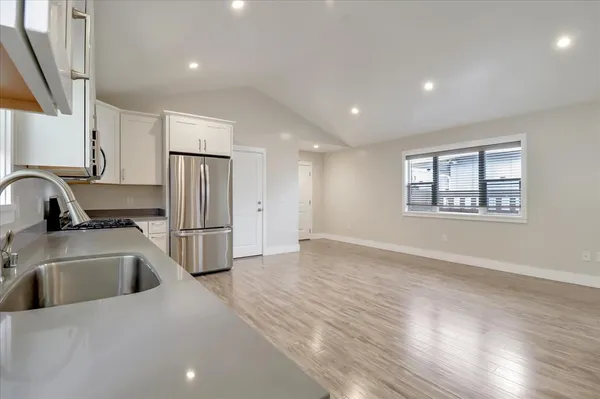 a kitchen with a refrigerator sink and wooden cabinets