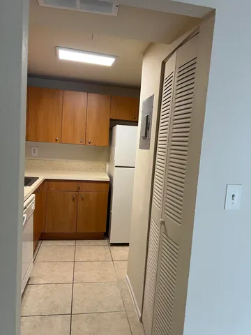 a kitchen with a refrigerator and white cabinets