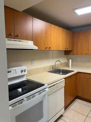 a kitchen with a sink a stove and cabinets