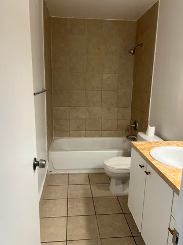 a bathroom with a granite countertop bathtub toilet and sink