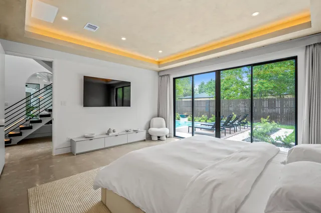 a bedroom with a bed and a flat tv screen on dresser