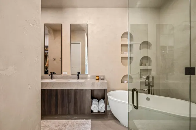 a bathroom with a double vanity sink mirror and bathtub