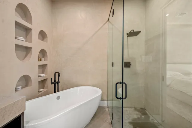 a bathroom with a bath tub with a shower