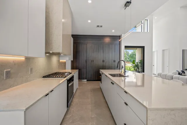 a open kitchen with stainless steel appliances granite countertop a sink a stove and a refrigerator