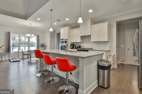 a kitchen with granite countertop a stove top oven sink and cabinets